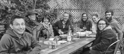 L'équipe de Mutation Digitale assise autour d'une table à l'extérieur avec de la nourriture et des boissons.